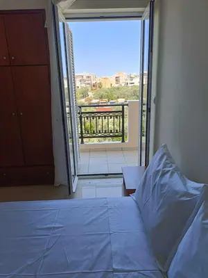 a bedroom with a bed and a view of a balcony at Despoina's Sea View Apartment in Chania Town