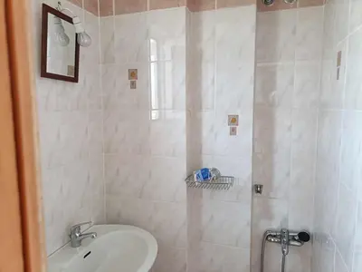 a bathroom with a shower with a sink and a toilet at Despoina's Sea View Apartment in Chania Town