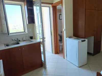 a kitchen with a sink and a washing machine at Despoina's Sea View Apartment in Chania Town