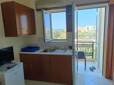 a kitchen with a sink and a view of a balcony at Despoina's Sea View Apartment in Chania Town