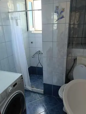 a bathroom with a shower and a washing machine at Despoina's Sea View Apartment in Chania Town
