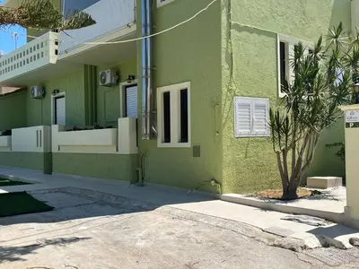 a green building with a tree in front of it at GREENHOUSE maleme in Ayiá