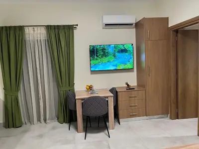a room with a table and a tv on the wall at GREENHOUSE maleme in Ayiá
