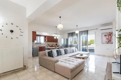 a living room with a couch and a kitchen at Lumina Apartment with Shared Pool in Perivólia