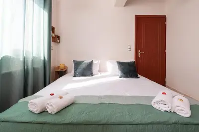 a bedroom with a bed with towels on it at Lumina Apartment with Shared Pool in Perivólia
