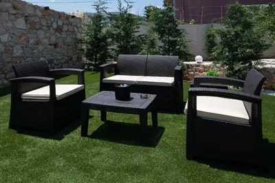 a group of chairs and a table on the grass at Lumina Apartment with Shared Pool in Perivólia