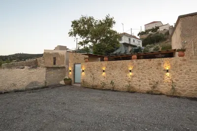 a stone wall with lights on it next to a building at Basiliko in Kalidhónia