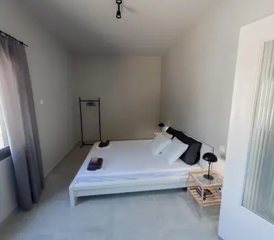 a bedroom with a white bed and a window at Rodi Apartment in Kolymvari