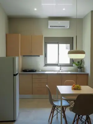 a kitchen with a table and chairs and a refrigerator at Rodi Apartment in Kolymvari