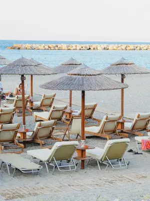 a group of chairs and umbrellas on a beach at Rodi Apartment in Kolymvari