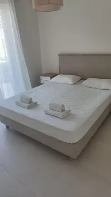 a large bed with two towels on top of it at \u4e24\u5367\u5ba4\u516c\u5bd3-\u5e26\u9732\u53f0\u82b1\u56ed in Chania Town