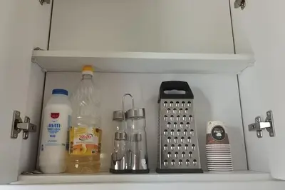 a kitchen shelf with bottles and other kitchen items at \u4e24\u5367\u5ba4\u516c\u5bd3-\u5e26\u9732\u53f0\u82b1\u56ed in Chania Town