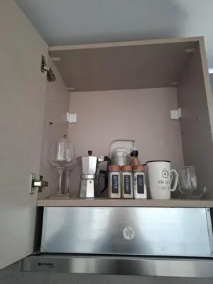 a shelf in a kitchen with cups and appliances at Kasteli Apartment in Kissamos