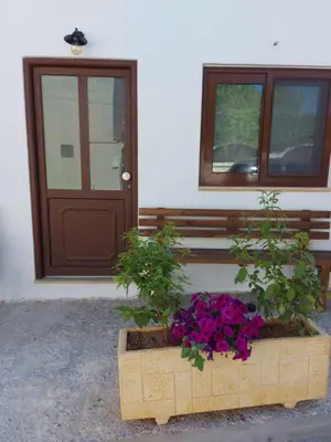 a wooden box with flowers in front of a door at Kasteli Apartment in Kissamos