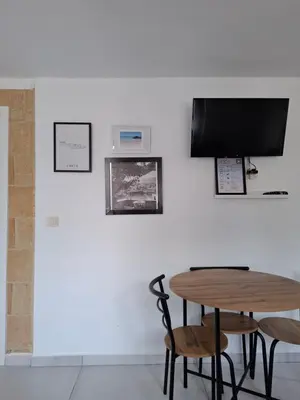 a table with two chairs and a television on a wall at Kasteli Apartment in Kissamos