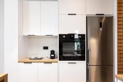 a kitchen with white cabinets and a stainless steel refrigerator at Centrale Apartment Chania in Chania Town
