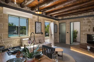a kitchen and living room with a stone wall at Semes luxury villas in Drapaniás