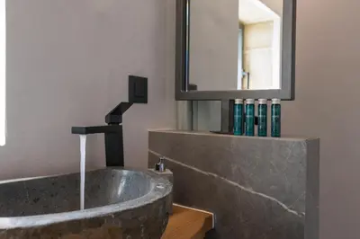a bathroom with a stone sink and a mirror at Semes luxury villas in Drapaniás