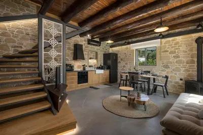 a kitchen and living room with a stone wall at Semes luxury villas in Drapaniás