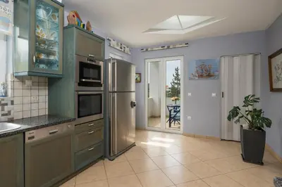 a kitchen with a stainless steel refrigerator at Maison Evelyn in Tsikalariá