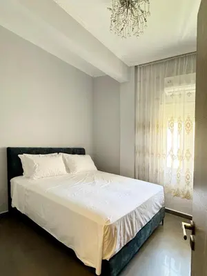 a bedroom with a white bed and a chandelier at Lia cozy apartment in Chania Town