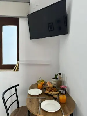 a dining room table with two chairs and a flat screen tv at Kasteli loft apartment in Kissamos