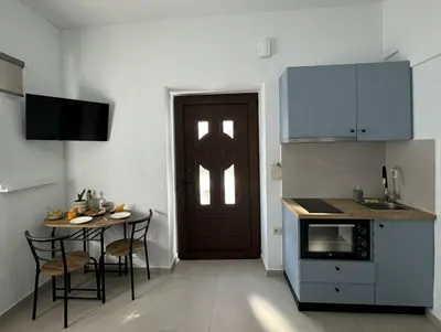 a kitchen with a table and a door and a table and chairs at Kasteli loft apartment in Kissamos