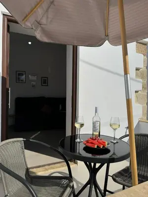 a table with two glasses of wine and a plate of fruit at Kasteli loft apartment in Kissamos