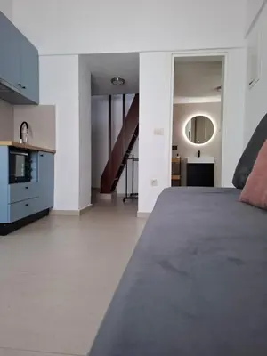 a bedroom with a large bed and a kitchen at Kasteli loft apartment in Kissamos