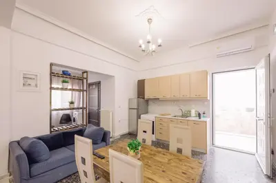 a kitchen and living room with a blue couch and a table at Koumbes home in Chania Town