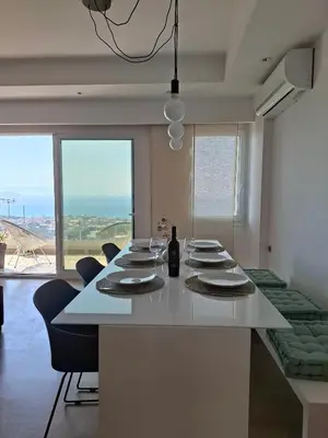 a dining room with a table with chairs and windows at UPapartment in Chania Town