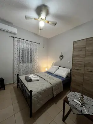 a bedroom with a bed and a ceiling fan at Agnanti in AsfendhilÃ©s