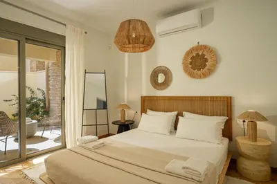 a bedroom with a large bed and a balcony at Panorama Seaview Village at Kalyves in Kalyves