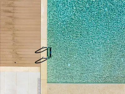 a pair of glasses sitting next to a swimming pool at Panorama Seaview Village at Kalyves in Kalyves