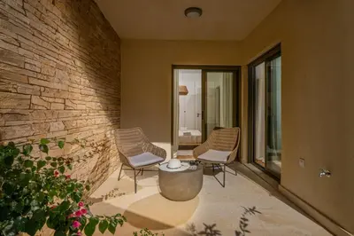 a patio with two chairs and a table and a brick wall at Panorama Seaview Village at Kalyves in Kalyves