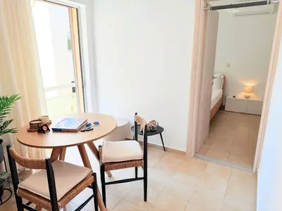 a room with a table and chairs and a bedroom at Yia Banaki 1 Min Walk To Beach old Town 7min Walk in Chania Town