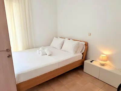 a small bedroom with a bed with white sheets and pillows at Yia Banaki 1 Min Walk To Beach old Town 7min Walk in Chania Town