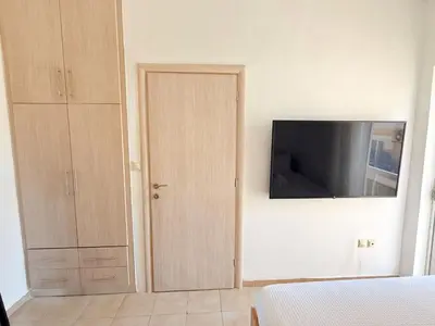 a bedroom with a door and a tv on a wall at Yia Banaki 1 Min Walk To Beach old Town 7min Walk in Chania Town