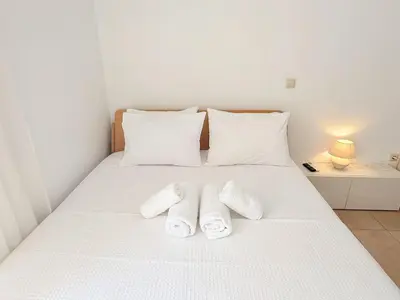 a white bed with two white towels on it at Yia Banaki 1 Min Walk To Beach old Town 7min Walk in Chania Town