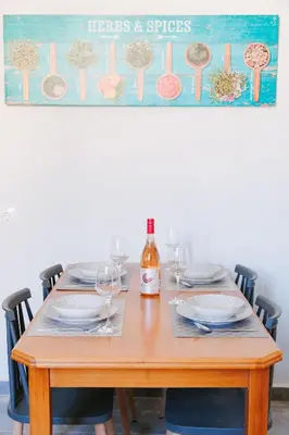 a table with plates and glasses and a bottle of wine at Be Crete - Villa Erofili in Chania Town