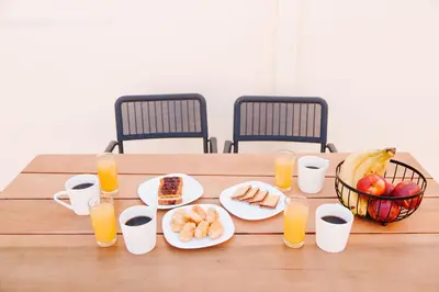a table with plates of food and glasses of orange juice at Be Crete - Villa Erofili in Chania Town