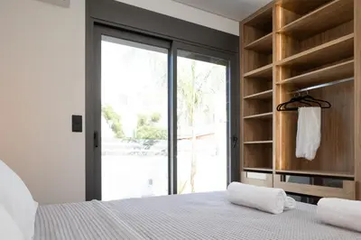 a bedroom with a bed and a large window at PhySea Villa in Kalathas