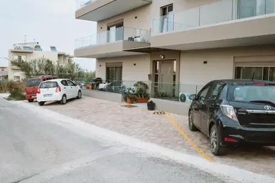 two cars parked in a parking lot in front of a building at Welcome U in Gerani Chanion