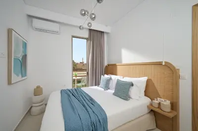 a bedroom with a bed with blue and white pillows at Mantis' House in Chania Town