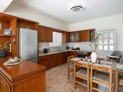 a kitchen with wooden cabinets and a stainless steel refrigerator at Casa Horizon in Palaiochóra