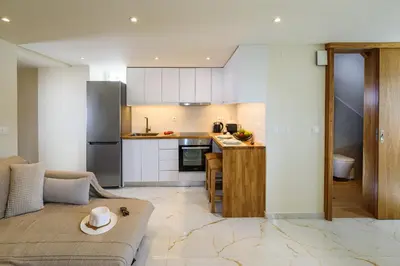 a living room with a couch and a kitchen at Nicolas Urban Luxury Living in Souda