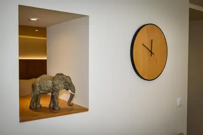 a clock on a wall next to a statue of an elephant at Nicolas Urban Luxury Living in Souda