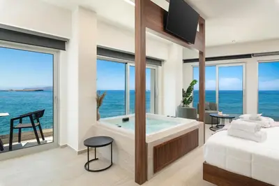 a bedroom with a tub with a view of the ocean at Elia Sea Suites in Chania Town