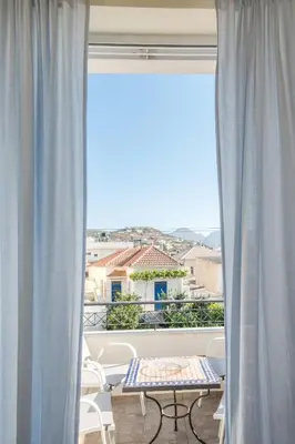 a room with a large window with a table and chairs at Kaloudis Apartment in Kissamos