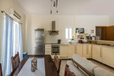 a kitchen with a table and a couch in a room at Kaloudis Apartment in Kissamos